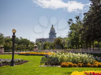 Flower beds and gardens of Civic Center Park with the gold leaf covered dome of State Capitol of Colorado in background