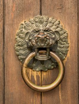 Lion head knocker on the entrance door of St Jacob Monastery in the medieval town of Regensburg, Bavaria, Germany