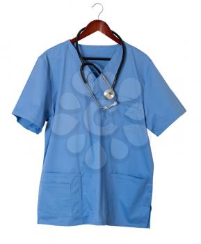 Blue medical scrubs uniform shirt hanging on a hanger with stethoscope and isolated against white background