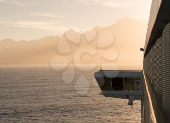 Cruise ship bridge cabin with the boat sailing to mountainous coastline of New Zealand near Milford Sound at dawn