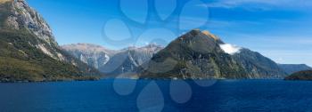 Panorama of Doubtful Sound on South Island of New Zealand aboard a cruise ship showing strong headwinds coming towards the ship