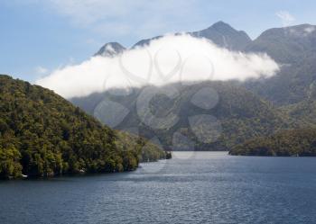 Sun lights a bright cloud in Doubtful Sound on South Island of New Zealand