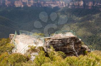 Woman hiker approaching overlook  at Pulpit Rock overlooking the Grose Valley and majestic Blue Mountains NSW Australia