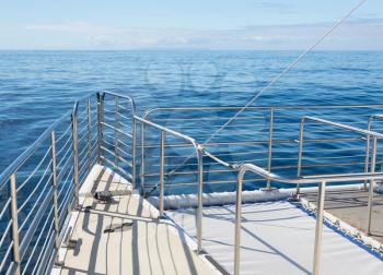 Large ocean going  catamaran at sea with focus on the stainless steel railings at the front of the boat