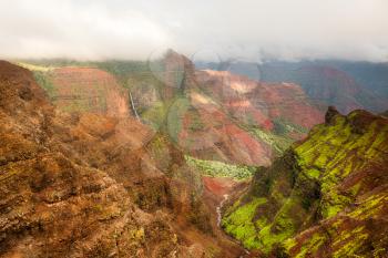 View of waterfall and river in the Grand Canyon of the Pacific or Waimea Canyon island of Kauai in the Hawaiian islands
