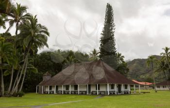 The old Waioli Huiia Mission building and hall in Hanalei Kauai with the Na Pali Mountains shrouded in mist in the background
