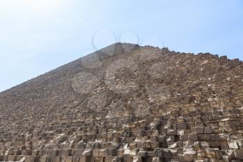 View up the side of Great Pyramid of Giza in Cairo Egypt on baking hot day with the heat haze and sun blinding the image at the top