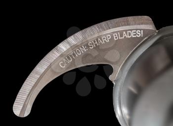 Isolated macro photo of the very sharp blade of food processor or blender with warning engraving about danger