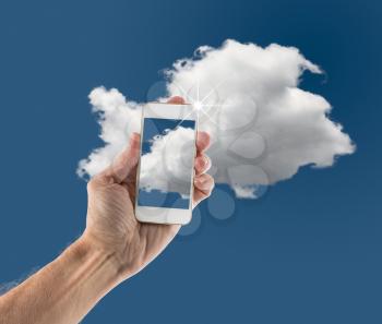 Concept image for cloud computing and online applications showing modern smartphone held in male hand up to sky