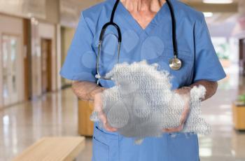 Senior male caucasian doctor with stethoscope in medical scrubs holding cloud computing shape. Connection to electronic medical records via WiFi to web services applications