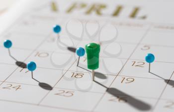 Calendar with push pins with focus showing tax day for filing is April 18 2017