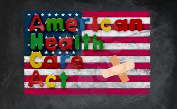 Childs magnetic letters spell American Health Care Act in congress. This is superimposed on a US flag chalked onto a blackboard with a bandage