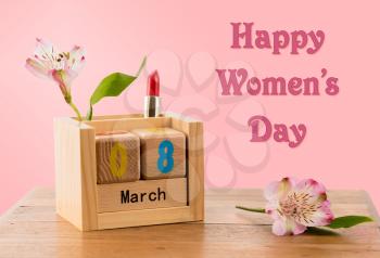 Happy Women's Day or International Womens Day celebrated on March 8th. Pink background image with wooden calendar and blossoms
