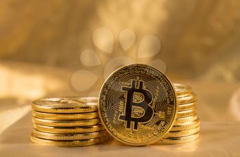 Stack of bit coins or bitcoin on gold background to illustrate blockchain and cyber currency