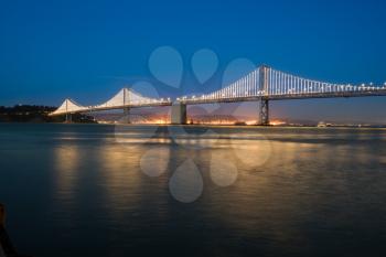 New LED lighting on the Bay Bridge between the downtown San Francisco and Treasure Island across the bay reflects in the water