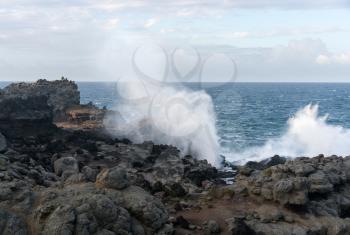 Famous Nakalele blowhole on north coast of Maui erupts as strong waves crash against the lava shoreline in Hawaii