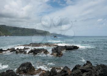 Black lava rocks line the shore at Keanae on the road to Hana in Maui, Hawaii