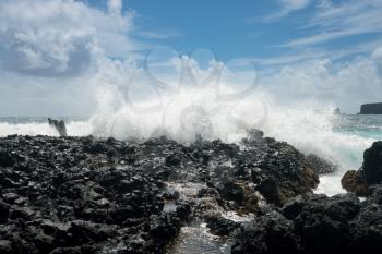 Black lava rocks line the shore at Keanae on the road to Hana in Maui, Hawaii