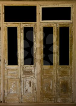 Two pairs of antique wooden french door with the windows cut out with black