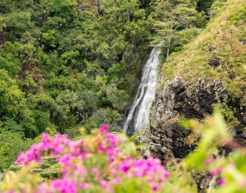Sun illuminates the twin falls of Opaekaa waterfall on Hawaiian island of Kauai