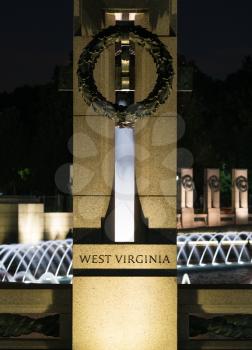 World War 2 memorial and fountains at night with West Virginia state column in foreground in Washington DC
