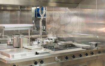 Food being cooked in commercial stainless steel kitchen in restaurant