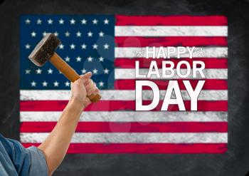 Hammer in arm of a construction worker in front of USA flag for Labor Day background poster