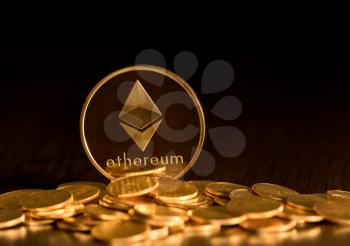 Stack of ether coins or ethereum on gold background to illustrate blockchain and cyber currency