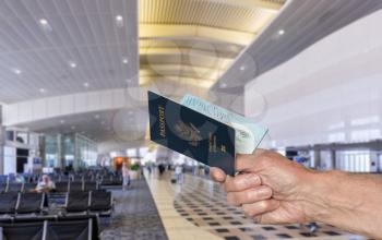 Senior caucasian arm holding an open USA passport to show to official in airport terminal for international flight