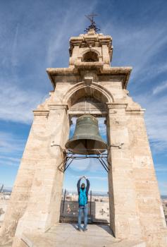Tourist takes photo of the bell at the top of the church tower of the Cathedral in Valencia