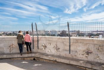 Couple look at panorama of city from top of the church tower of the Cathedral in Valencia