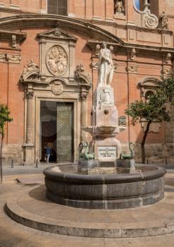 Statue and fountain outside Church of Santo Tomas in old city of Valencia in Spain