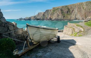 White wooden rowing boat ready to launch at pier at Hartland Quay in North Devon, England