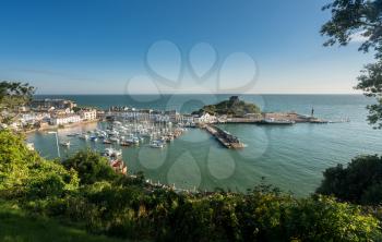 ILFRACOMBE, DEVON UK - JULY 24:  Harbor at sunrise on 24 July 2017 in Ilfracombe, UK. The Damien Hirst statue Verity was erected in 2012