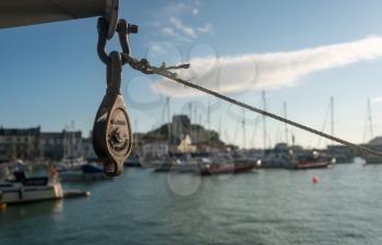 Early morning sun illuminates pulley or winch in front of the harbor at Ilfracombe, Devon