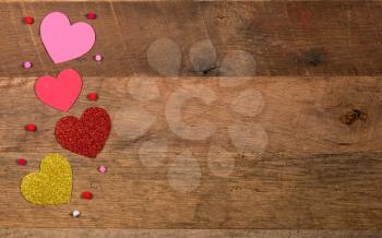Heart shaped cutouts on wooden surface and background for Valentines day with copy space