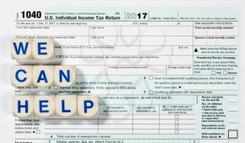 Close macro photo of USA IRS tax form 1040 for year 2017 taken from above with WE CAN HELP spelled out in letters on the form