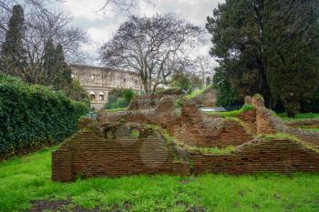 Remains of brick walls in garden of Domus Aurea with Colosseum in background