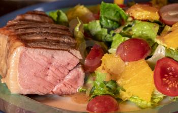 Thick New York strip beef steak cooked in sous vide and grilled on plate with lettuce salad