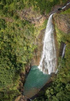 Aerial view of Manawaiopuna Falls and landscape of hawaiian island of Kauai from helicopter flight