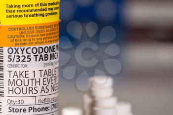 Oxycodone is the generic name for a range of opoid pain killing tablets. Prescription bottle for Oxycodone tablets and pills with USA flag in background