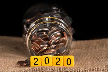 Cash in savings jar for good luck as dice for 2020 is spread on table for New Years celebrations