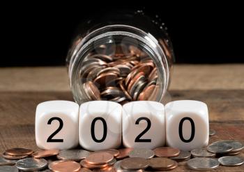 Cash in savings jar for good luck as dice for 2020 is spread on table for New Years celebrations