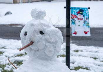 Close up of snowman head with a winter holiday flag in the background