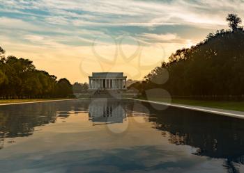 Setting sun illuminates Lincoln Memorial in Washington DC with reflections in new Reflecting Pool