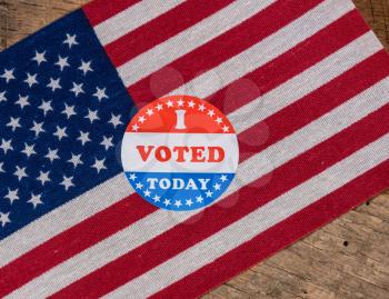 I Voted Today sticker  for voters in the US elections with USA flag on rustic wooden table