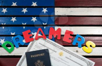 Dreamers concept on wooden USA flag with passport and naturalization certificate