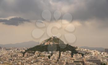 Storm clouds above Lycabettus hill with the city of Athens surrounding it
