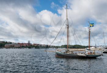 Old wooden sailing boat or barge by City Hall in Stockholm Sweden