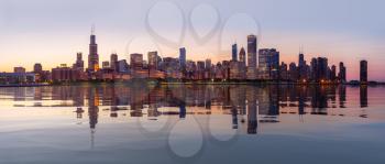 Panorama of cityscape skyline of Chicago from the old observatory at sunset and reflected in artificial water surface